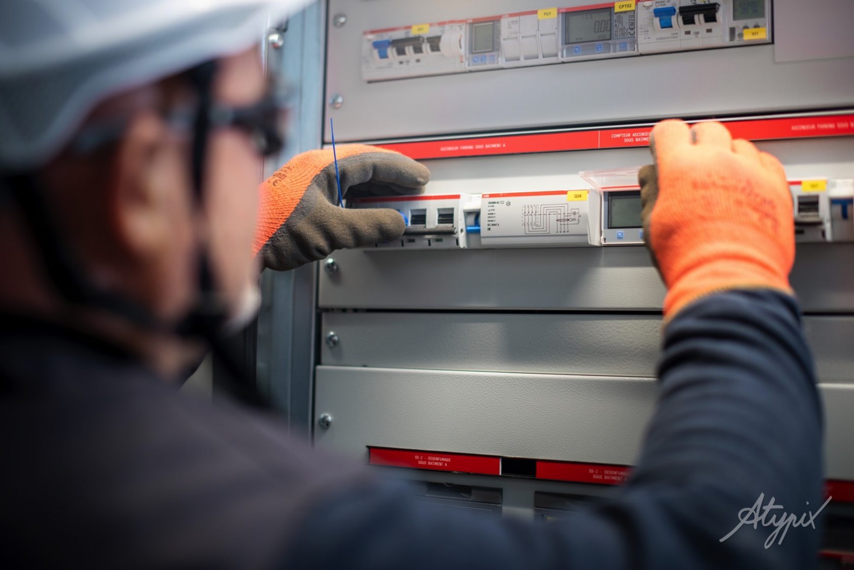 Technicien en train d’installer un tableau électrique dans le cadre d’un projet d’électricité tertiaire et industrielle dans le Grand Ouest.